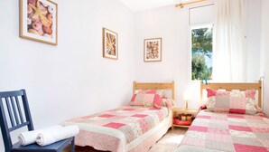 A bedroom with two single beds, a wooden chair, and a nightstand with a lamp. - 1DIAZ 01 - Lovely and cozy villa with private pool and garden situated in a quiet residential area only 1km from the beautiful Aigua Xelida beach (Tamariu)