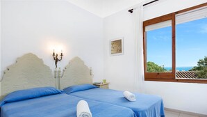 A double room with two beds, a candelabra, a framed picture, and a window with a view. - 1CAR 01 - Basic apartment with communal pool near the beach of Llafranc (Llafranc)