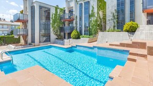 A modern building with a swimming pool, large windows, and balconies. - 1PINEDA 01 - Cozy apartment for 8 persons  situated a few minutes walk from the beach of  Calella de Palafrugell (Calella de Palafrugell)