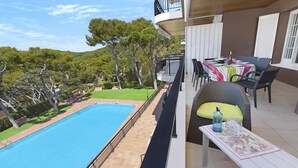A balcony with a pool, outdoor furniture, and a view of the surrounding greenery.