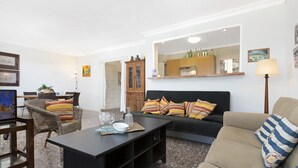 A living room with a sofa, armchairs, a coffee table, and a dining area with a table and chairs.