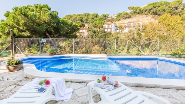A swimming pool with lounge chairs and a potted plant. - 2PON01 - Beautiful house with private pool located in a quiet area near the beach (Lloret de Mar)