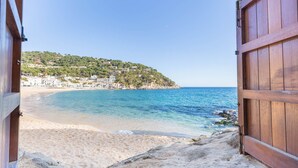 A beach view through an open wooden door, leading to a sandy beach and a clear blue sea. - 1MIRAD 01 - Beautiful house renovated with great taste, with fantastic views of the sea and direct access to the beach of Llafranc (Llafranc)