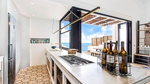 A modern kitchen with a large island, a built-in oven, and a wine rack. - 1MIRAD 01 - Beautiful house renovated with great taste, with fantastic views of the sea and direct access to the beach of Llafranc (Llafranc)