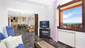 A living room with a TV, a sofa, and a view of the sea. - 2MAER01 - House for 9 people with private pool located near the beach of Blanes (Blanes)