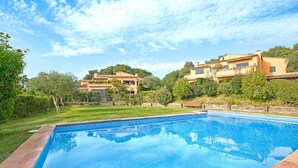 A swimming pool with a clear blue water surface, surrounded by a well-maintained lawn and a few trees. - 1PAST 02 - Magnificent house with communal swimming pool in Llafranc, only 450m away from the beach (Llafranc)