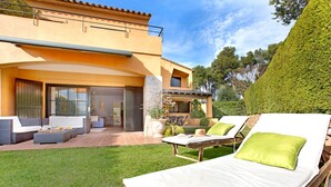 A modern house with a patio area featuring lounge chairs and a dining set. - 1PAST 02 - Magnificent house with communal swimming pool in Llafranc, only 450m away from the beach (Llafranc)