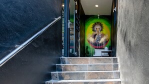 Una escala que porta a una habitació amb un mural al mur.