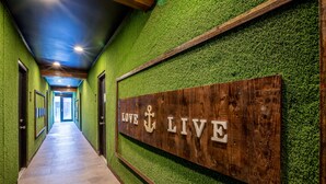 Un passadís amb parets verdes i un senyal de fusta que diu "LOVE LIVE".