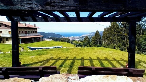 Espaço ao ar livre coberto com vista para um edifício e um barco em um campo gramado.