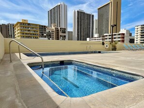 A rooftop swimming pool with a view of high-rise buildings.