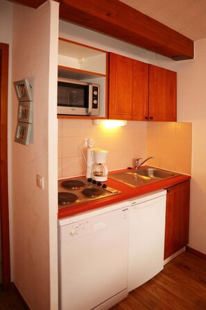 A compact kitchen with a built-in microwave, a coffee maker, and a dishwasher. - Ski-in/ski-out & foot of the slopes, 3rd floor, swimming pool, sauna, balcony, tv, ski locker, 49m² (Les Orres)