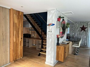 Un intérieur moderne avec un escalier en bois, un coin cuisine et un bar.