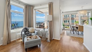 A modern living room with a view of the sea, a dining area, and a balcony. - 🚢Luxury Seattle Waterfront Walk to Cruise Ship & Pike Place -Waterfront Views🎡 (Seattle)