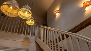 Una escalera con barandilla blanca y viga de madera.