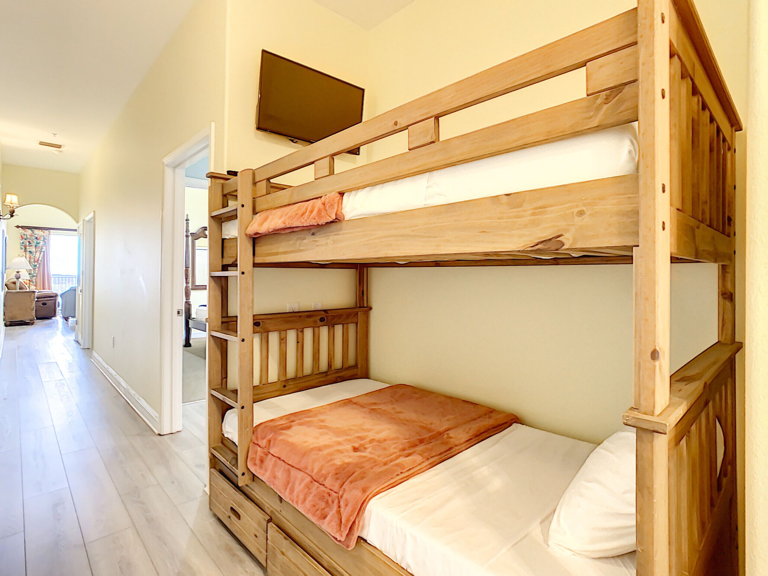 A bunk bed room with a television above it.