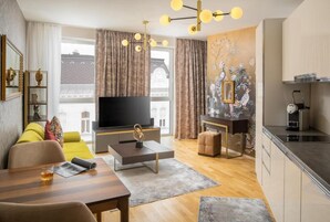 Una sala de estar moderna con televisor de pantalla plana, una mesa de comedor y una cocina con estufa.