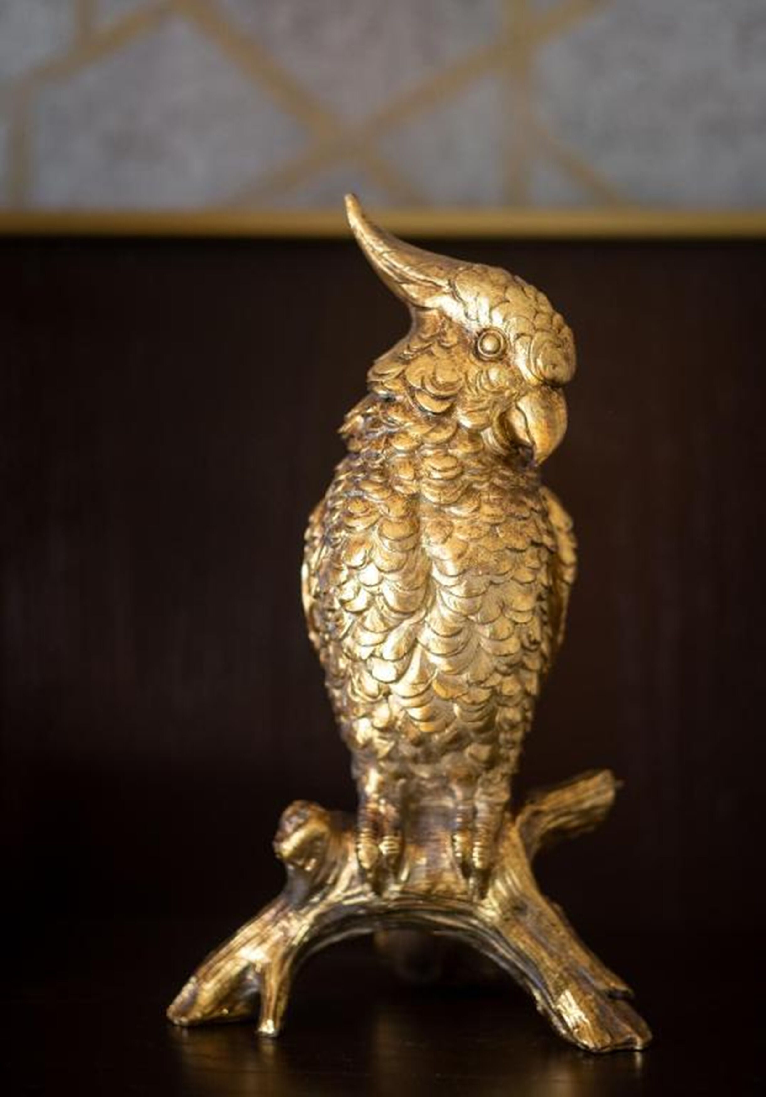 A golden owl statue on a wooden stand.