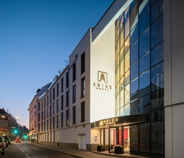 A modern building with a large glass facade and a sign reading "ABIES HOMES". - Abieshomes Serviced Apartments - Schönbrunn (Vienna)