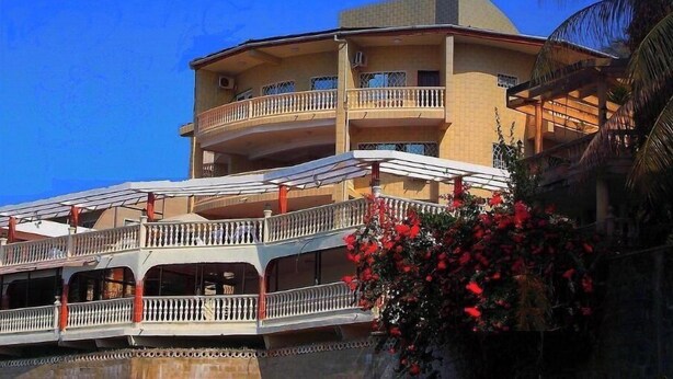 A multi-story building with balconies and a covered walkway. - Seaside Suites and Hotel Room #101 (Freetown)