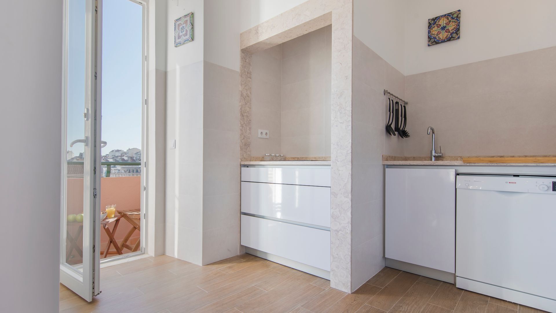 A modern kitchen with white cabinets, a Bosch dishwasher, and a small countertop.