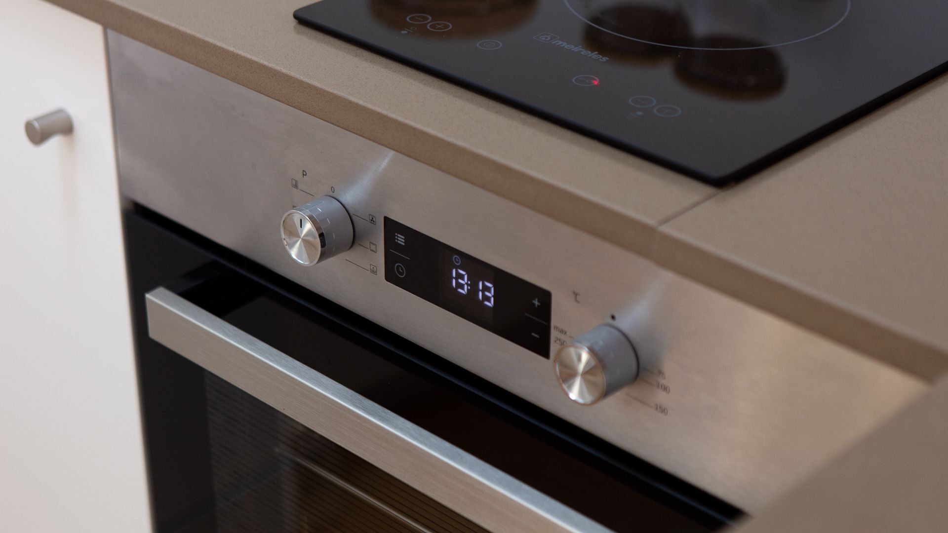 A kitchen with a stainless steel oven and a digital control panel.