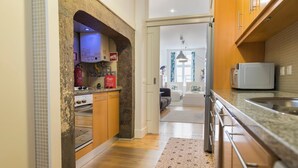 A modern kitchen with granite countertops, a built-in oven, and a microwave. - Downtown Cosy Wonder by LovelyStay (Lisboa)