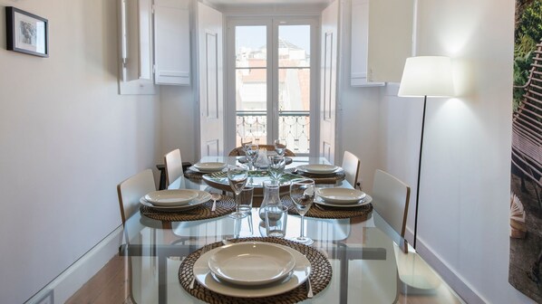 A dining table set for six with clear glass tops, surrounded by chairs.