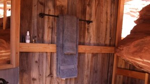 A rustic bathroom with wooden walls, a white sink, and a toilet. - Luxury Glamping Tent in Moab | Sleeps 2 (Moab)
