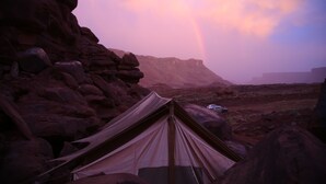 A tent in a rocky landscape with a mountain in the background and a rainbow. - Luxury Glamping Tent in Moab | Sleeps 2 (Moab)
