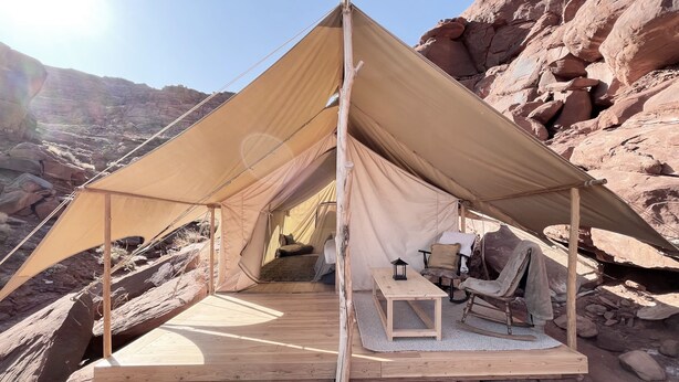 A tent with a wooden deck, a table, chairs, and a lantern. - Luxury Glamping Tent in Moab | Sleeps 2 (Moab)