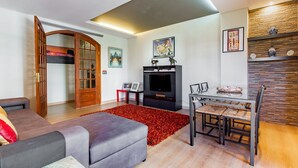 Una sala de estar moderna con un sofá, televisor y comedor con una mesa de vidrio.