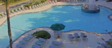 A pool area with sun loungers and a fountain.