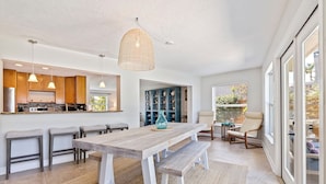 A modern kitchen with wooden cabinets, a large island, and pendant lighting. - 511 Harbor Hideaway – Waterfront Retreat w/ Heated Pool, Dock, Golf Cart & Walk to Beach (Indian Rocks Beach)