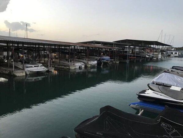Un puerto deportivo con barcos amarrados bajo estructuras cubiertas.