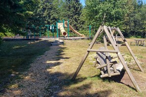 A playground with a slide and swings in a park. - Lutsen Sea Villas (Lutsen)