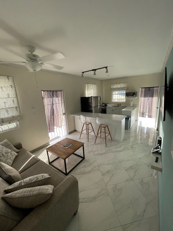 A modern living room with a sofa, coffee table, and a ceiling fan.