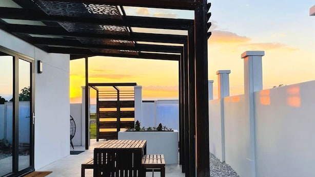 A patio with a pergola, a fire pit, and a seating area. - Vacation home with private hot tub.  (Stockton)