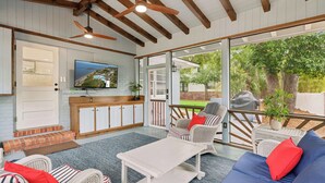 Un espacio habitable de concepto abierto con televisor, asientos y vistas al exterior.