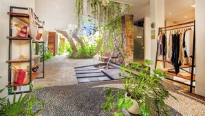 Eine Hotelhalle im Boutique-Stil mit Steinwand, einer Holztreppe und einem Kleiderständer.