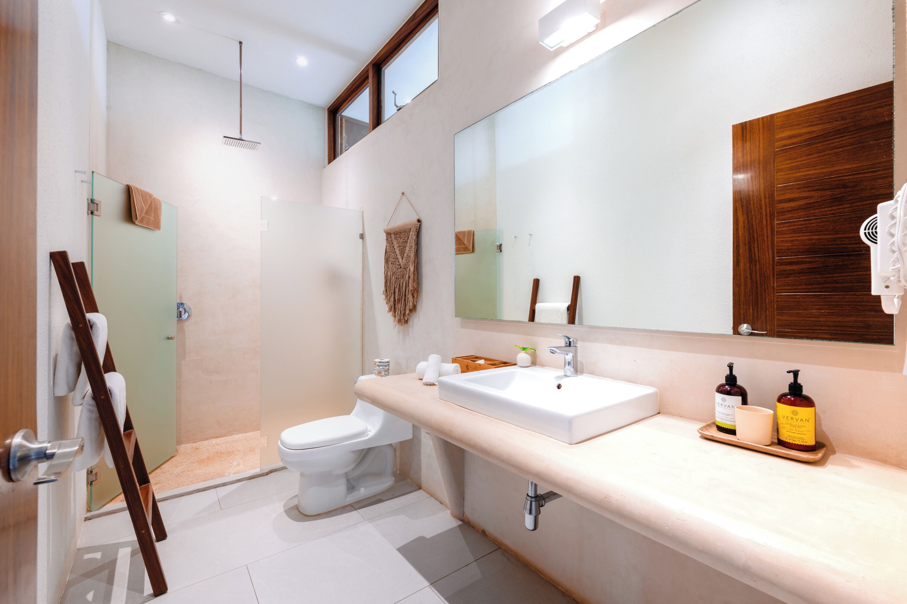 A modern bathroom with a shower, toilet, and vanity.