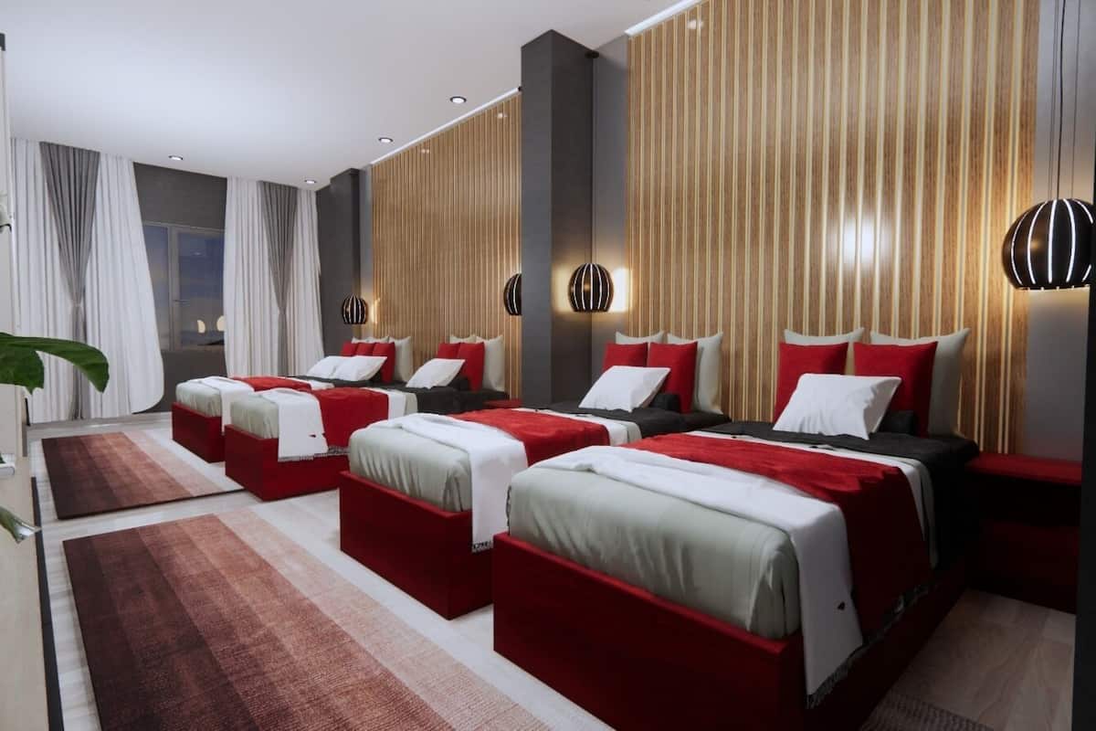 Une chambre d’hôtel moderne avec trois lits, une grande fenêtre avec des rideaux et un mur décoratif en bois.