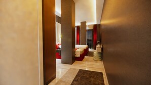 A modern hotel room with a bed, a red sofa, and a small table with books. - Airport İnalens Konaklama (Arnavutköy)