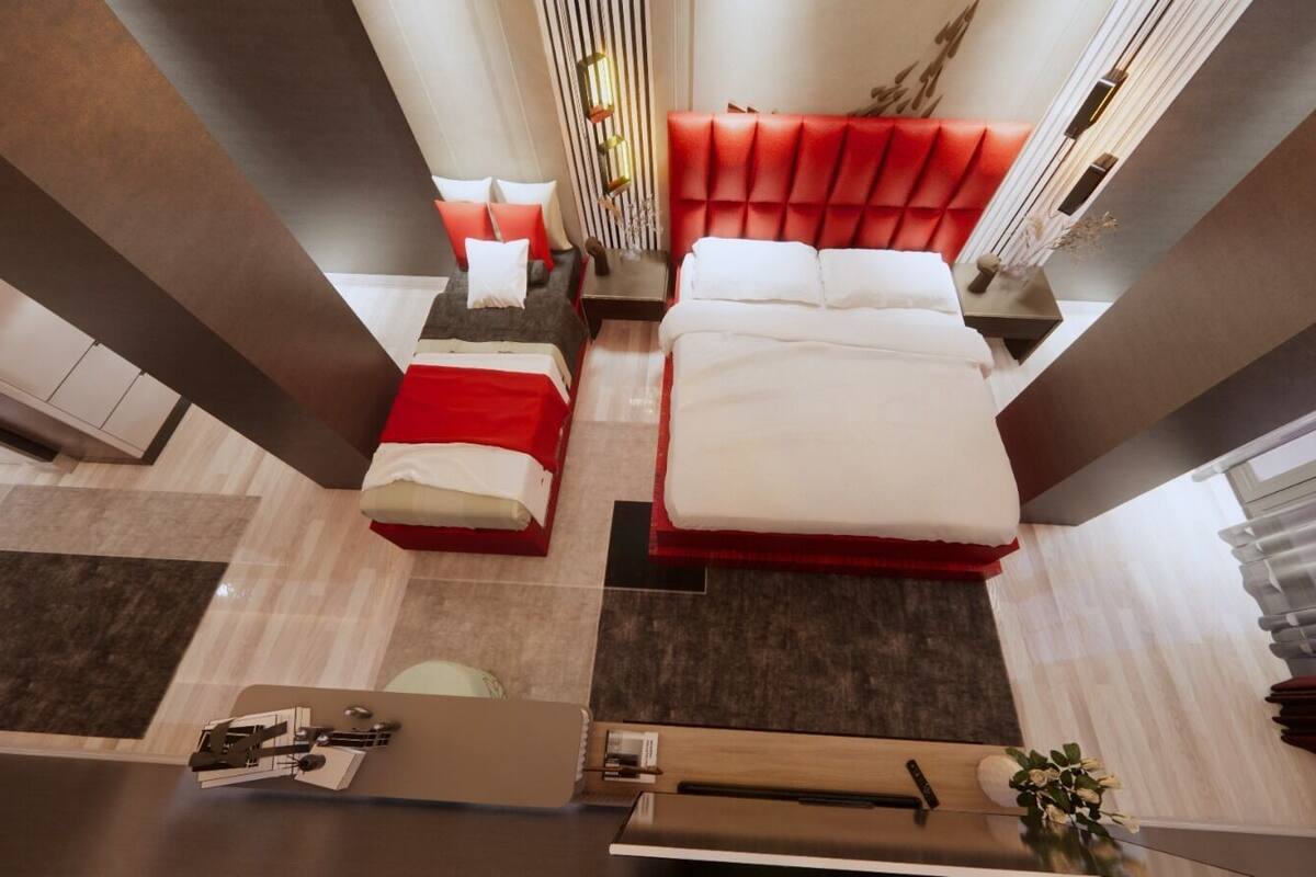 Une chambre d’hôtel moderne avec deux lits, un bureau et un petit coin salon.