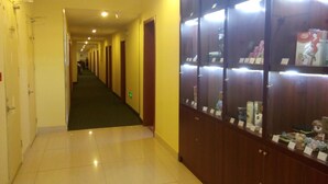 Passadís d'hotel amb sòl de rajola, taulers de fusta a la dreta i portes al costat esquerre.