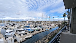 A marina with numerous boats docked, a calm water body, and a clear sky.