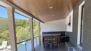 A covered outdoor area with a pool, a table with chairs, and a view of the surrounding landscape. - 7 Bedroom Villa in Vila Real (Vila Real)