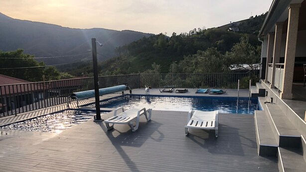 A pool area with lounge chairs, a pool, and a view of mountains. - 7 Bedroom Villa in Vila Real (Vila Real)