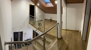 A multi-level interior with a staircase, wooden flooring, and a skylight. - 7-Bedroom Villa in Vila Real (Vila Real)