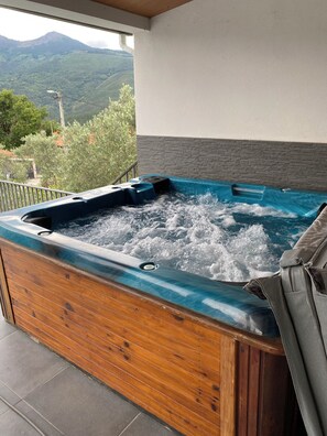A hot tub with a wooden exterior and a view of a mountainous landscape. - 7-Bedroom Villa in Vila Real (Vila Real)